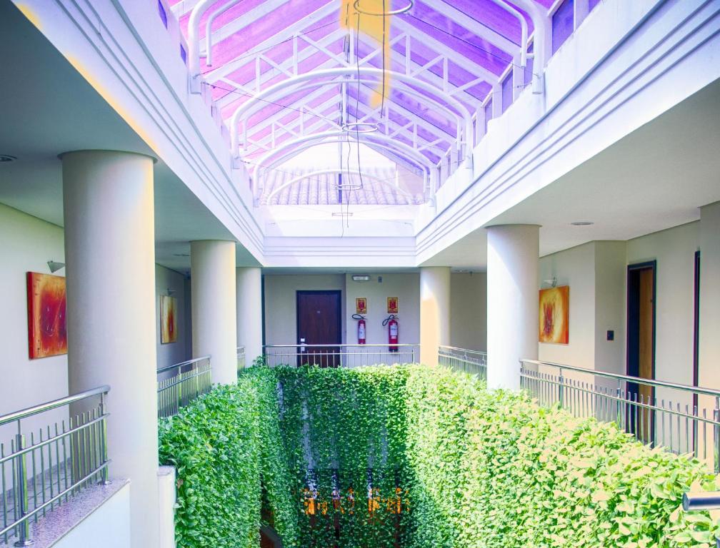 a hallway with a green hedge in a building at Pousada dos Girassóis in Palmas