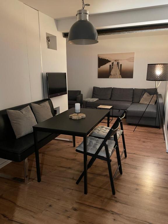 Deichappartement-Brüggen في بروخن: غرفة معيشة مع طاولة سوداء وأريكة