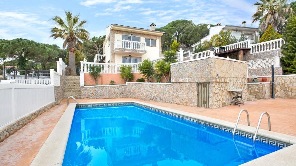 a villa with a swimming pool in front of a house at 2Vil01 - Lloret de Mar in Lloret de Mar