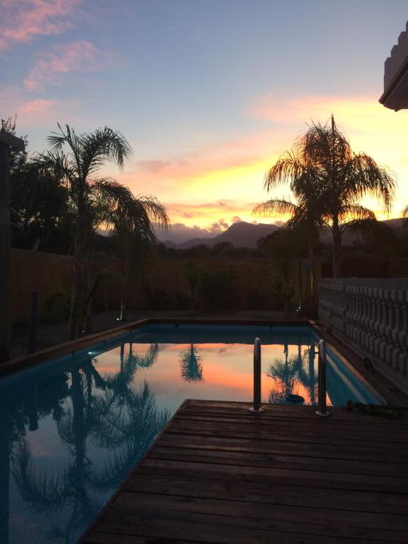una piscina con tramonto sullo sfondo di Corte Vena a Bianco