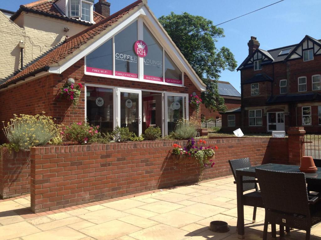 a cafe with a table in front of a brick building at The Royal Hotel in Mundesley