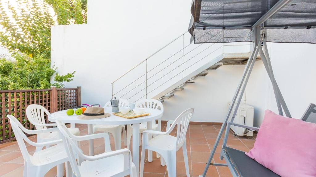 una mesa blanca y sillas en un balcón con escalera en 1Solive - Calella de Palafrugell en Calella de Palafrugell