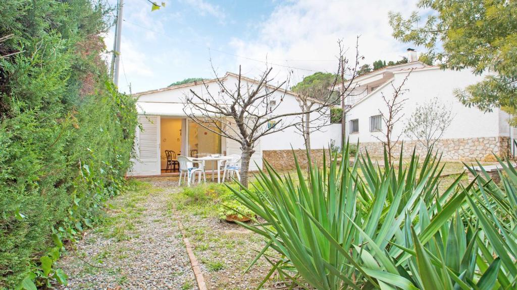 a garden with a table and a house at 1 Sire - Llafranc in Calella de Palafrugell