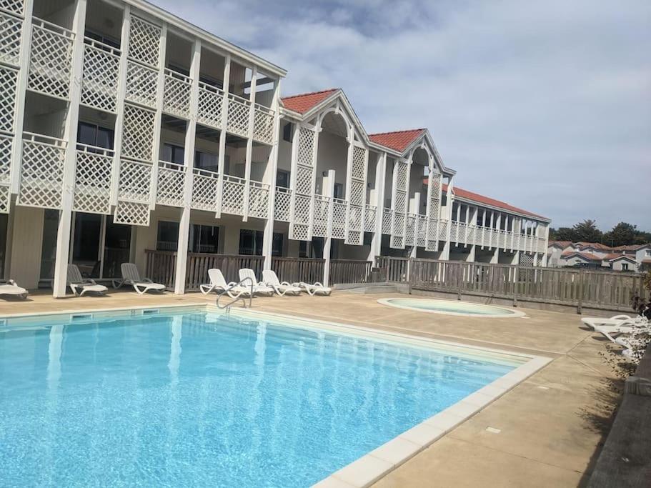 une piscine en face d'un bâtiment dans l'établissement Appartement 200m de l'océan avec piscine extérieure, à Mimizan