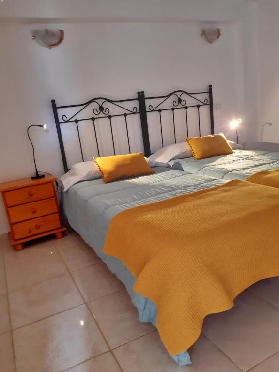 um quarto com 2 camas com almofadas amarelas em Apartamento La Aldea Pueblo Gran Canaria 2A em San Nicolás