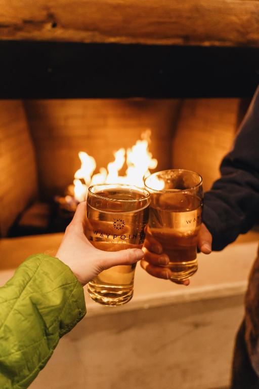 two people holding up two glasses of beer at Waypoint Hotel in Bend