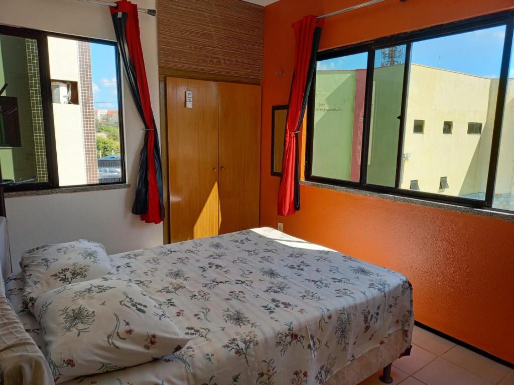 een slaapkamer met een bed in een kamer met ramen bij Localização privilegiada, muito próximo do BEACH PARK in Aquiraz
