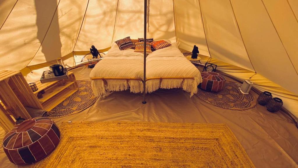 ein Schlafzimmer in einem Zelt mit einem Bett darin in der Unterkunft AMANI - Aap in Lichtaart