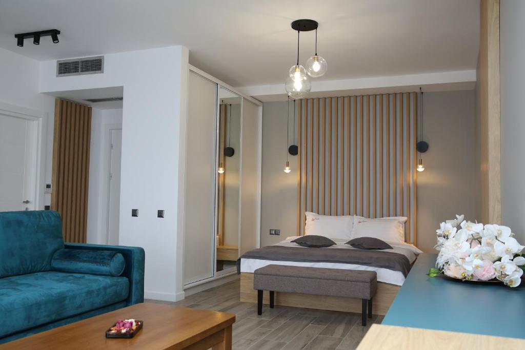 ein Schlafzimmer mit einem Bett und einem blauen Sofa in der Unterkunft ResHome in Focşani
