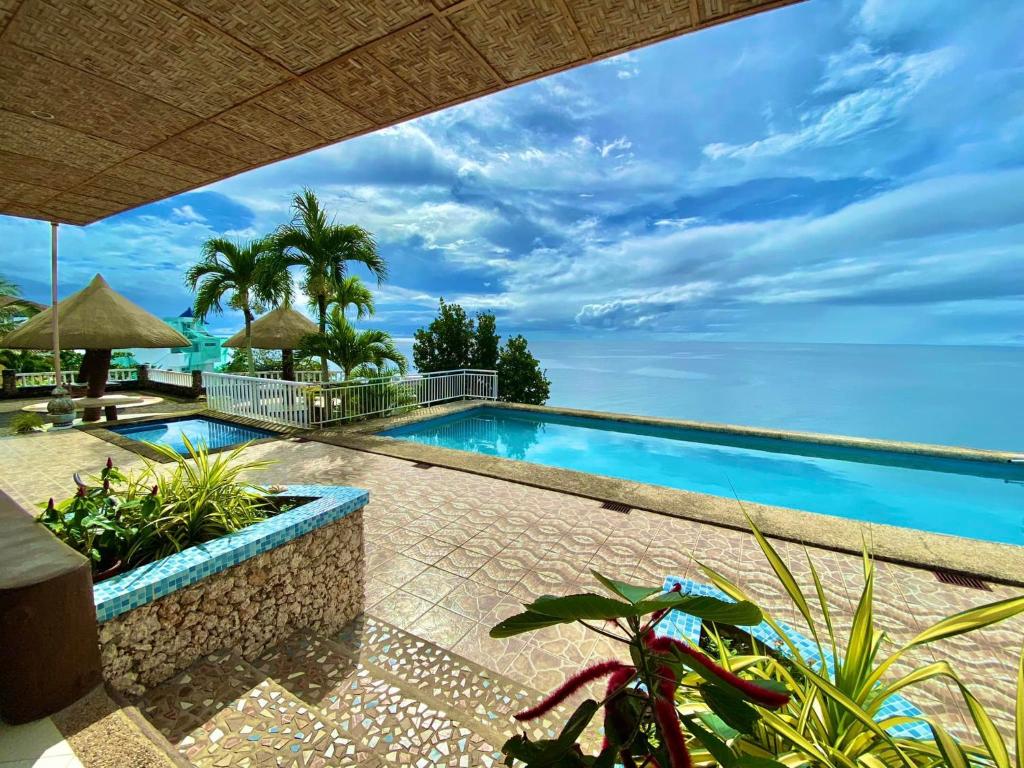 a swimming pool with a view of the ocean at Azure Camotes Resort Hotel in Camotes Islands