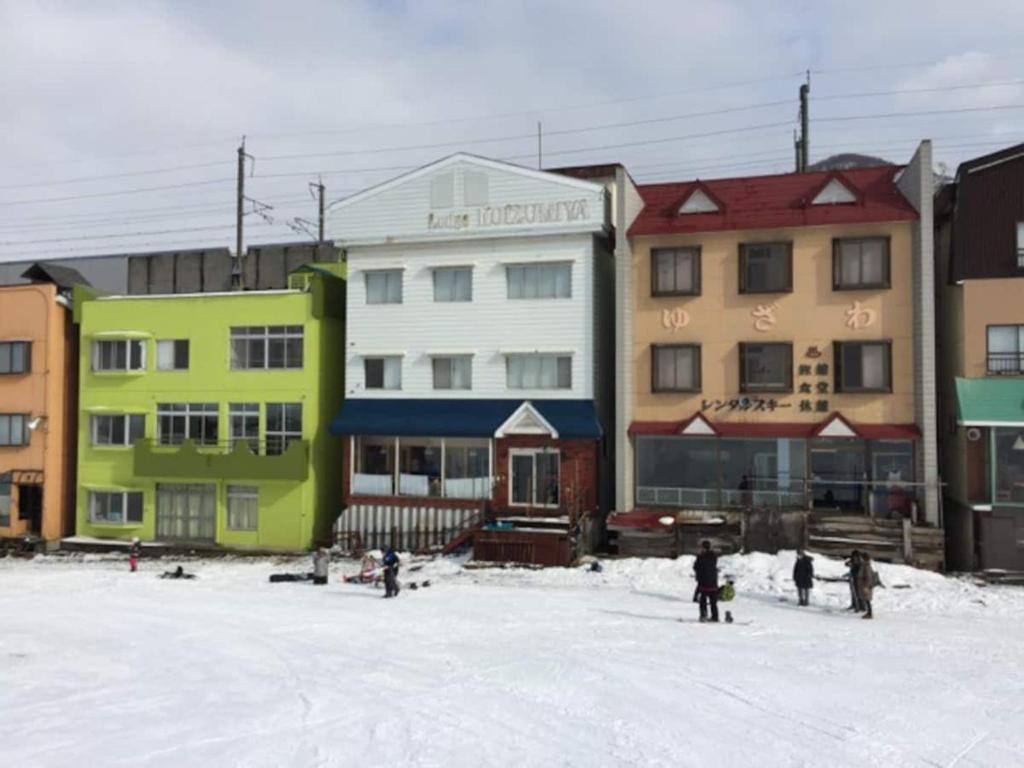 een groep mensen die in de sneeuw voor gebouwen staan bij Ryokan Yuzawa - Vacation STAY 14222v in Yuzawa