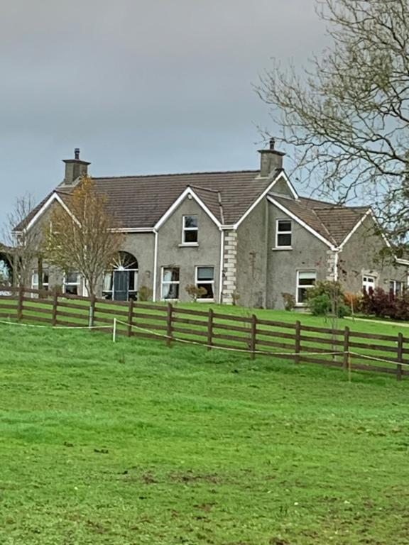 a large house with a fence in front of it at Windyridge in Aghagallon