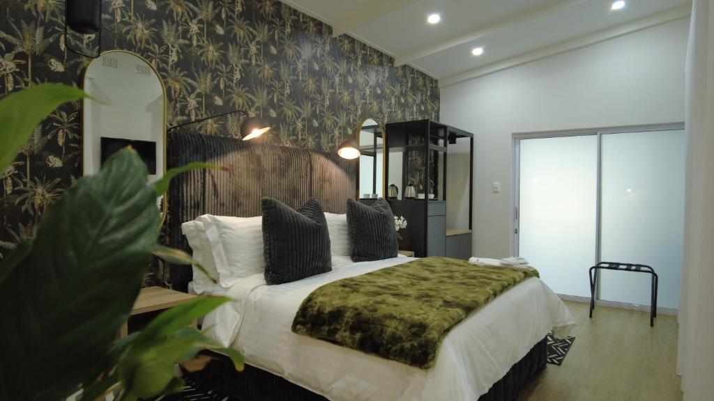 um quarto com uma cama grande e um cobertor verde em The Executive Bed and Breakfast em East London
