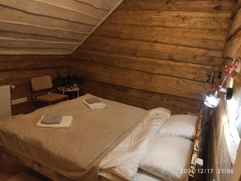 Tysovets的住宿－Сімейний Затишок Готель，木制客房内的一间卧室,配有一张床