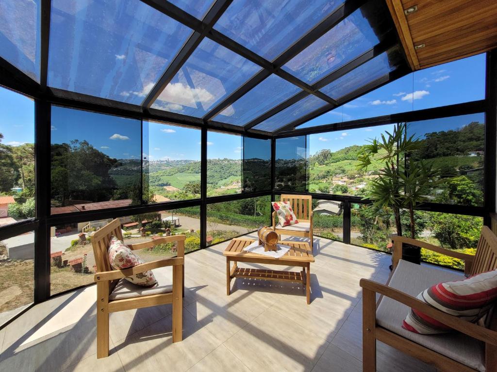 a glass house with a view of the mountains at Vinícola & Pousada Terragnolo in Bento Gonçalves