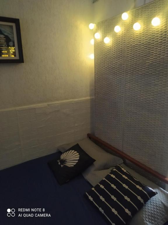 Habitación con 2 almohadas en una cama con ducha en Apartamento Studio ao Lado da Praia com Wi-Fi e TV Smart en Santos