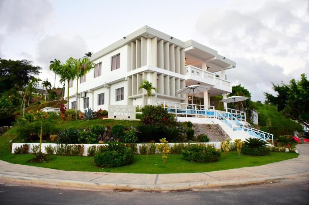 una casa blanca con un jardín delante de ella en Casa Docia Hotel, en Santa Bárbara de Samaná