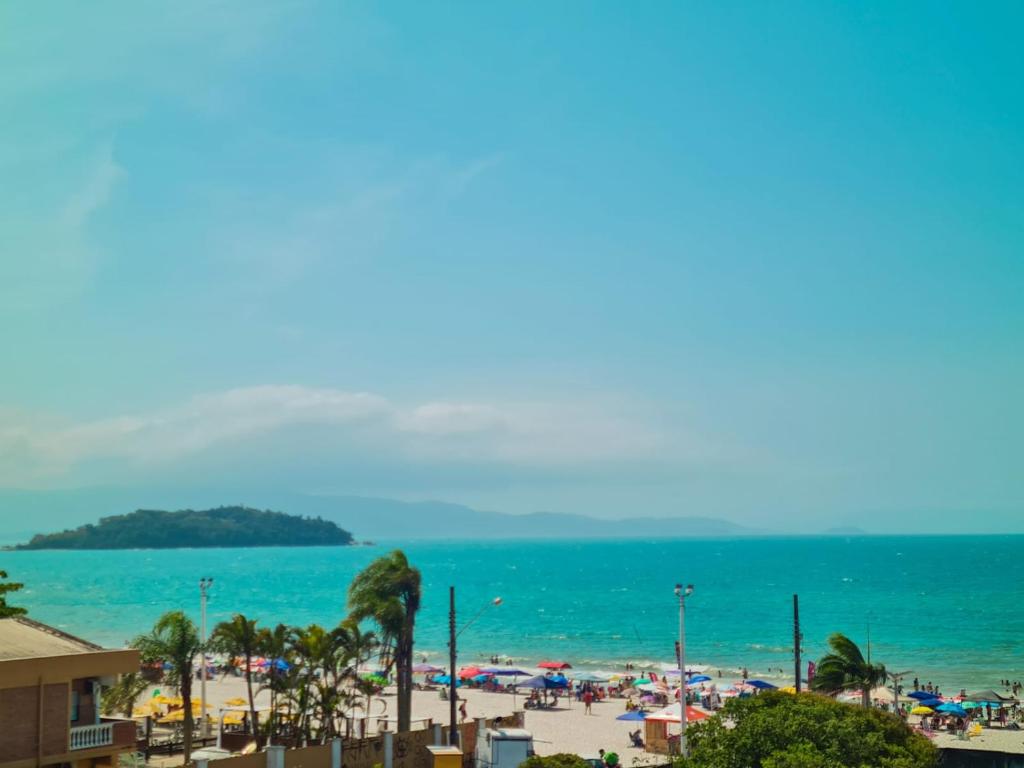 - une vue sur la plage bordée de palmiers et l'océan dans l'établissement Lexus Residence Apto 304, à Florianópolis