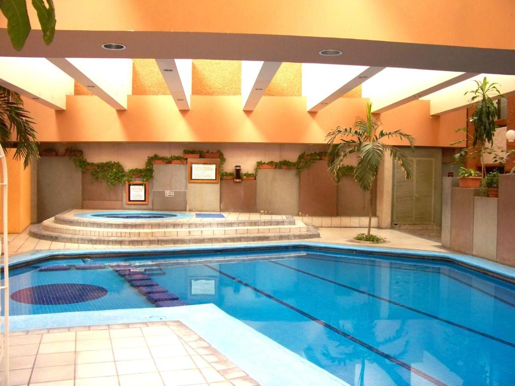 瓜達拉哈拉的住宿－鄉村廣場酒店，一座带室内游泳池的大楼内的大型游泳池