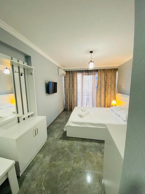 sea view rooms in Batumi في Angisa: غرفة كبيرة بها سرير ومرآة