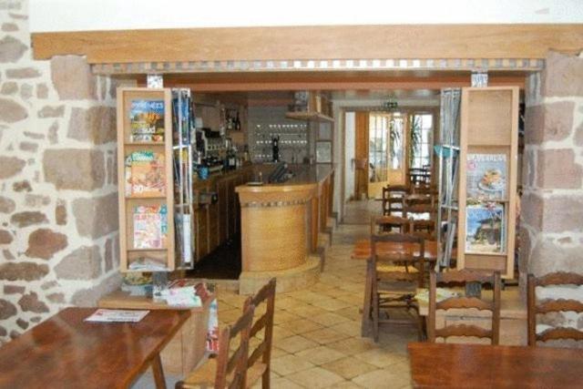 a restaurant with wooden tables and chairs and a bar at Hotel Restaurant Noblia in Bidarray
