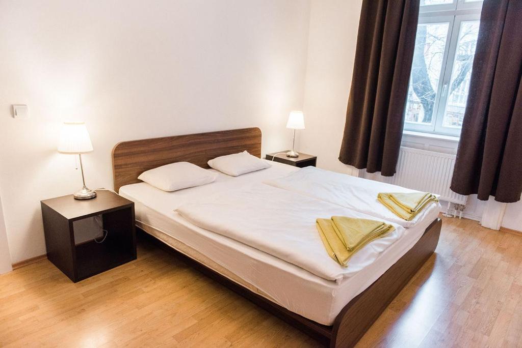 ein Schlafzimmer mit einem großen Bett mit zwei Tischen und zwei Lampen in der Unterkunft Lion Apartments in historical center, Bratislava Old Town in Bratislava