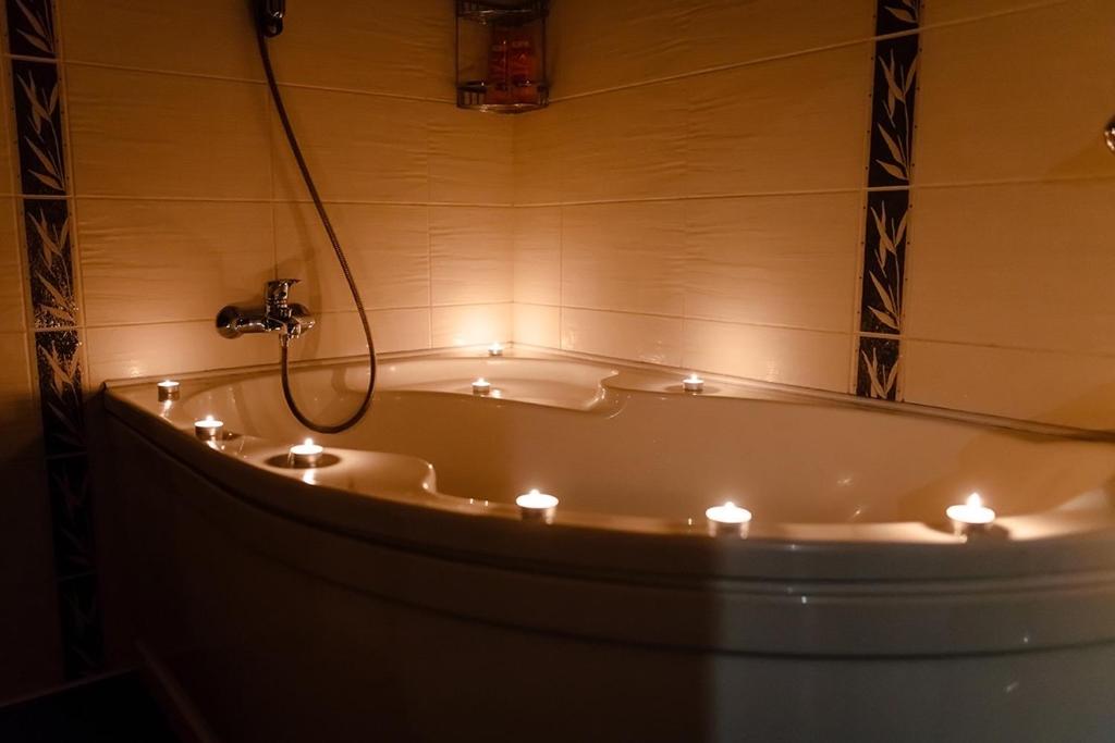 a bath tub with lit candles in a bathroom at Leninskaya Apartments in Mogilev