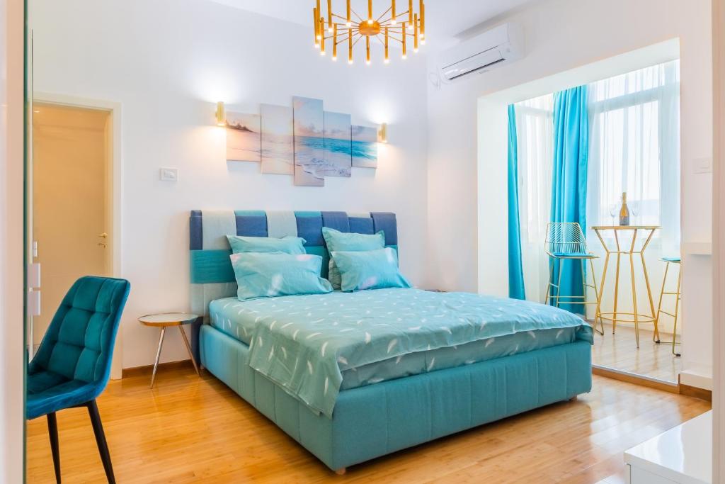 a bedroom with a blue bed and a blue chair at New Studio Carturesti - City Center in Bucharest