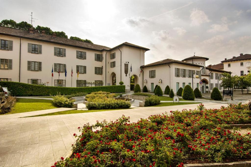 a group of buildings with flowers in a courtyard at Hotel Parco Borromeo - Monza Brianza in Cesano Maderno