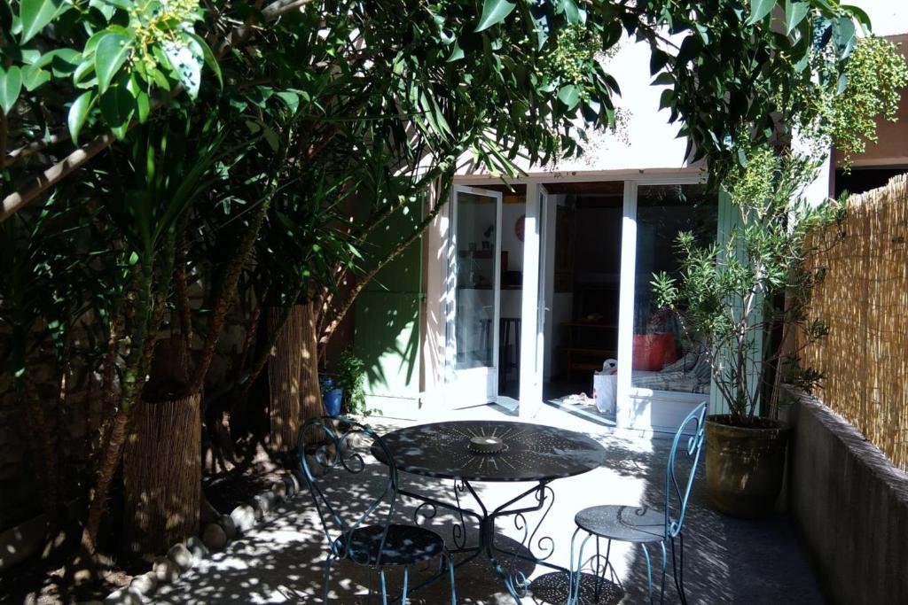 a patio with a table and chairs and trees at STUDIO of 24m with small patio in Avignon