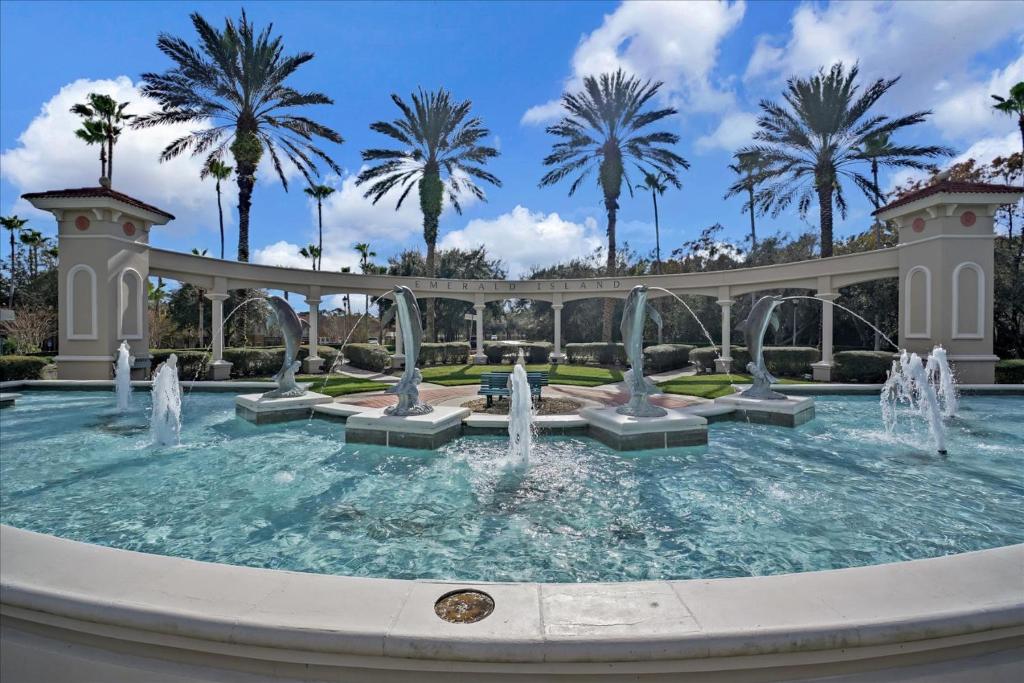 een fontein in een park met palmbomen op de achtergrond bij EXCELLENT 7 Bedroom EIR Vacation Villa - PRIVATE POOL in Kissimmee