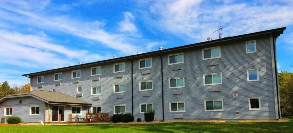 ein großes graues Gebäude mit seitlichen Fenstern in der Unterkunft Paddle Wheel Inn in Oregon