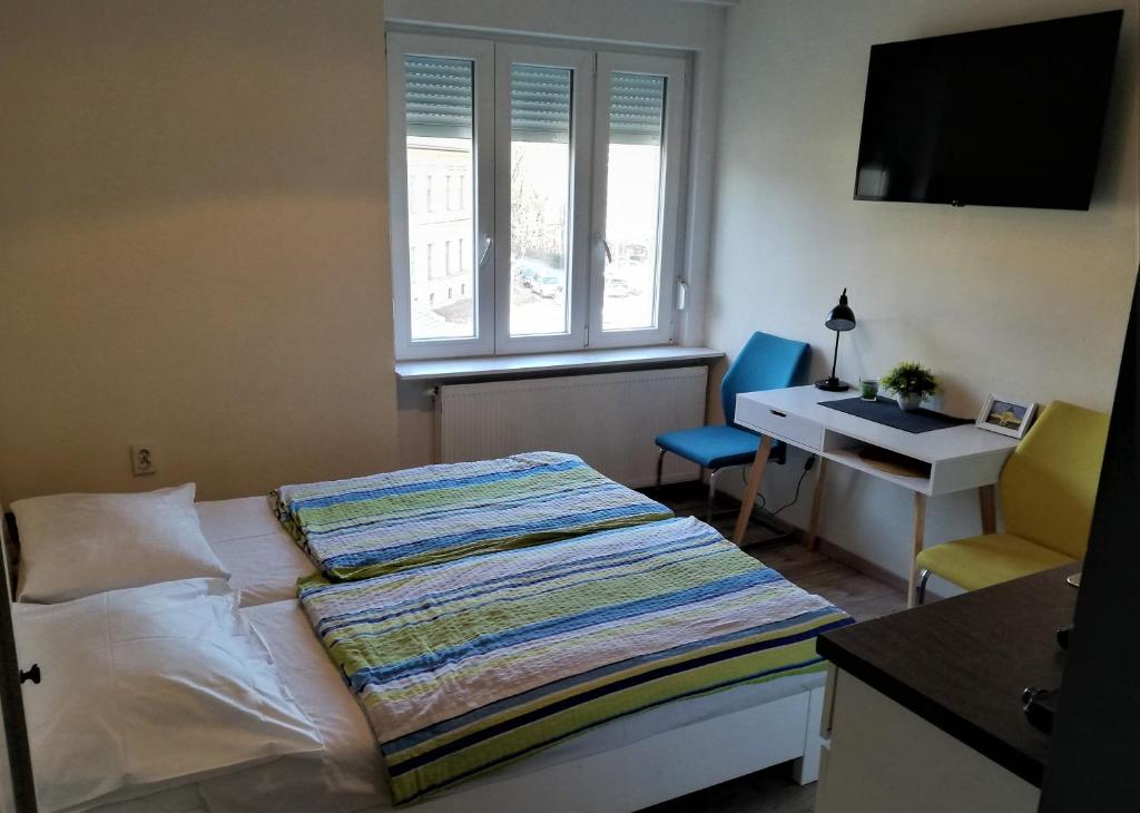 a bedroom with a bed and a desk and a window at Angela Studio Apartments in Zagreb