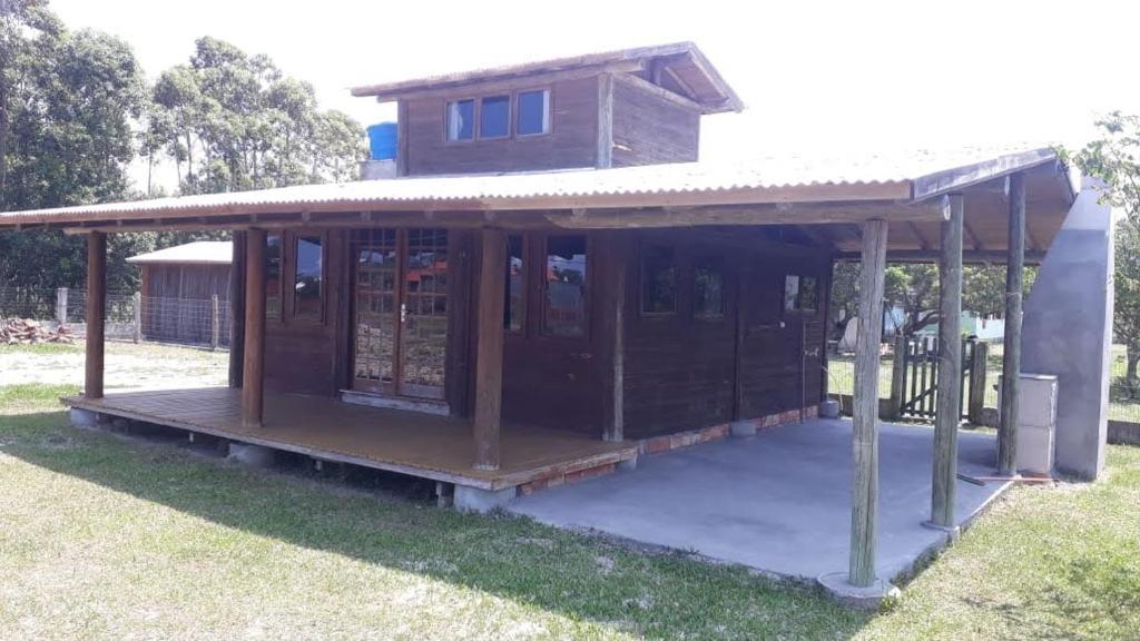 un bâtiment avec une terrasse couverte et une maison dans l'établissement Cabana de praia Galheta, à Laguna