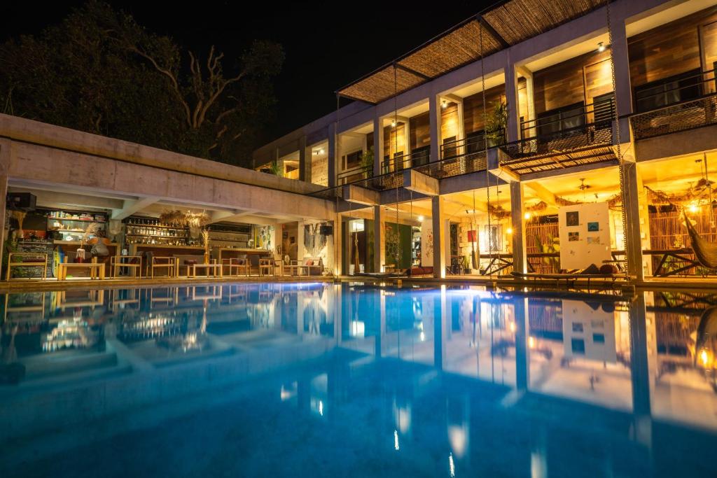 a swimming pool in front of a building at night at Hotel Makaabá Eco-Boutique in Bacalar