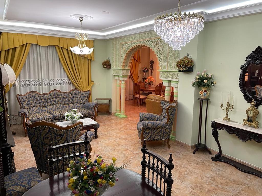 een woonkamer met meubilair en een kroonluchter bij Casa Luisa in Granada