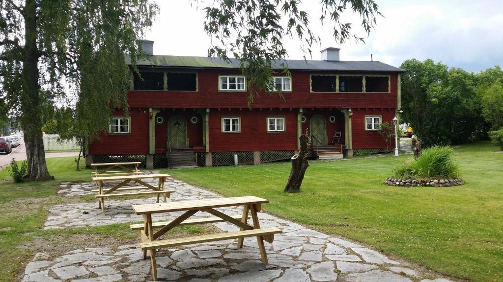 two picnic tables in front of a red building at Annexet Gästgivaregården Sunne in Sunne