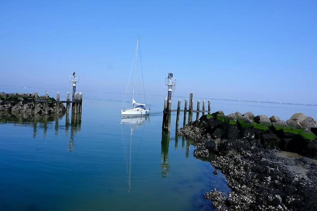 un bateau est amarré à un quai dans l'eau dans l'établissement IJsvogel Apartment, Duplex Family Home 4-bed located on the largest saltwater lake, à Bruinisse