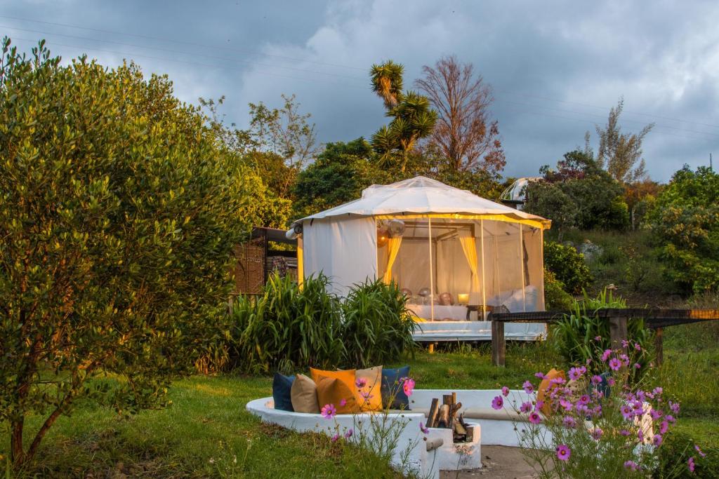a gazebo in a garden with a couch in the yard at Chigüa Glamping in Ráquira