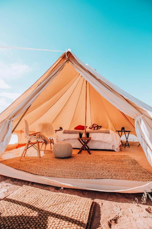 a tent in the desert with a bed and a chair at Wander Camp Grand Canyon in Valle