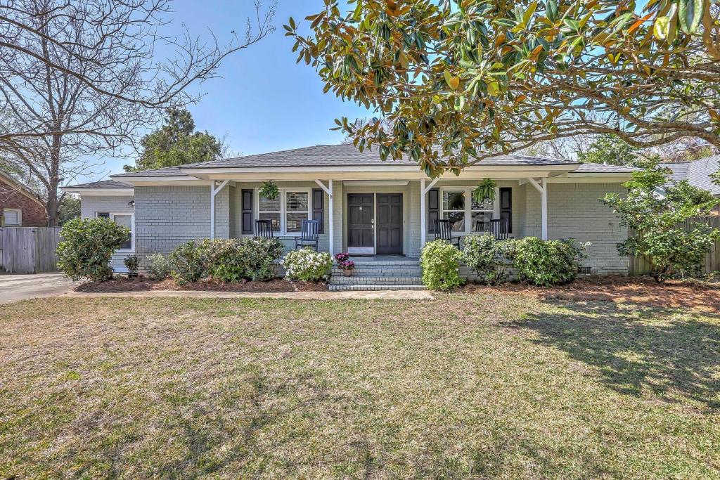 a white house with a porch and a yard at Charming House with Patio, 3 half Mi to Beach! in Charleston