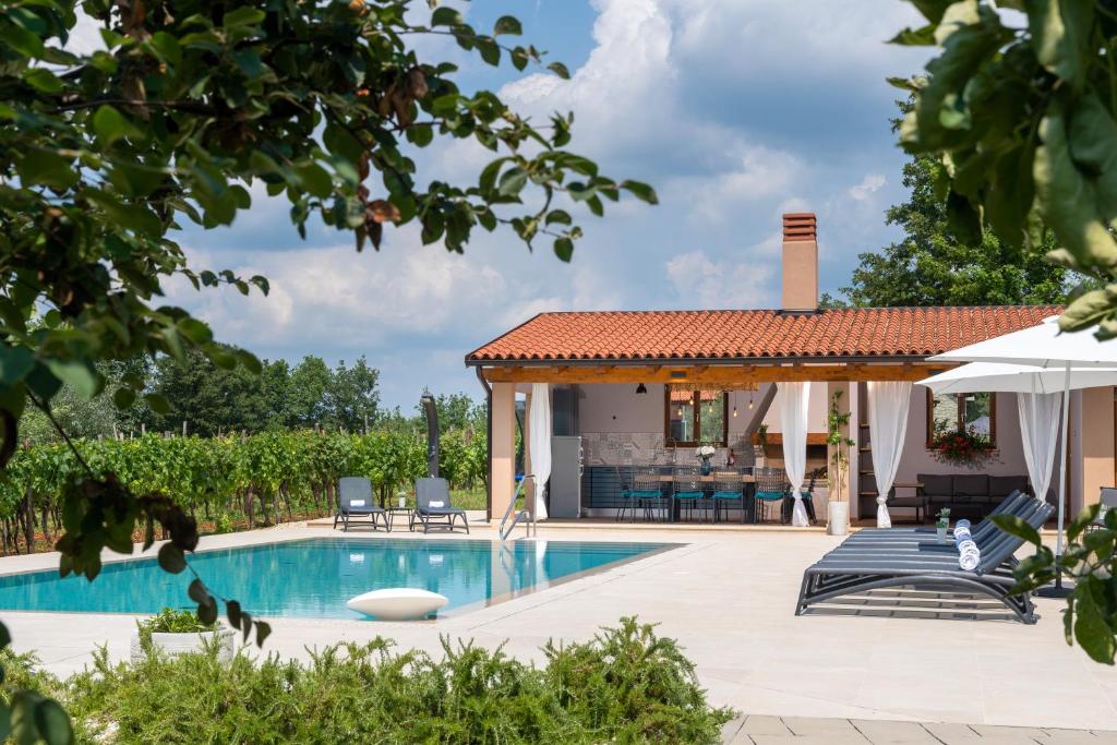 a swimming pool with a gazebo and a house at Vitis Apartment Istra in Tinjan