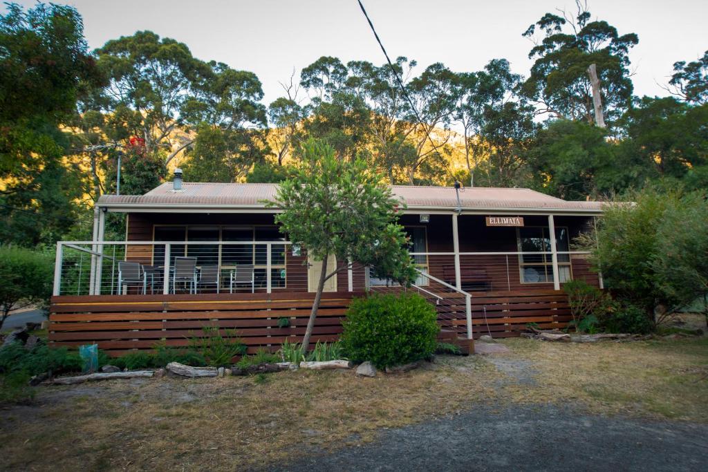 a wooden house in the middle of a yard at Ellimata Holiday Cottage in Halls Gap
