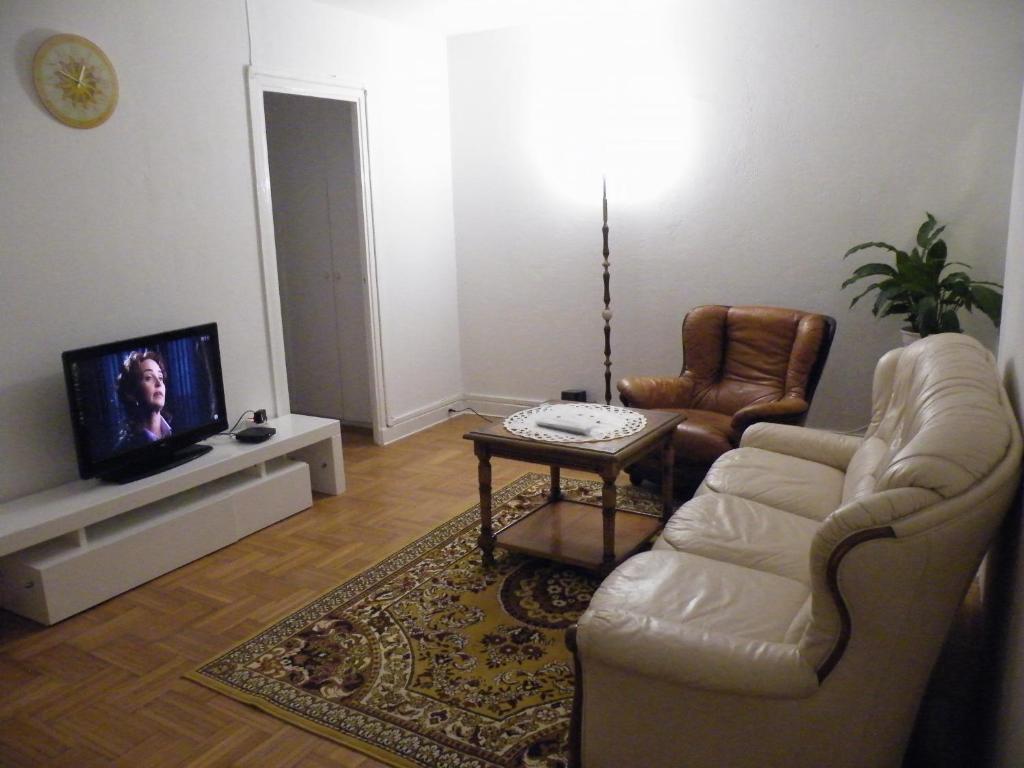 sala de estar con sofá, silla y TV en APPARTEMENT F3 -PLAISIR MOINS CHER - Jusqu'a 8Personnes, en Le Mée-sur-Seine