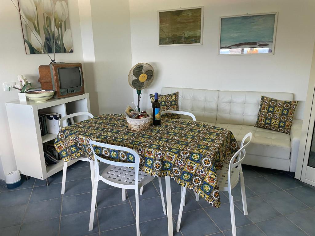 une salle à manger avec une table, des chaises et un canapé dans l'établissement Villa Alice, à Santo Stefano di Camastra