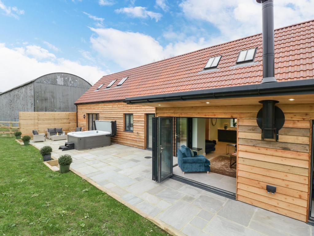 eine Erweiterung des Hauses mit einer Terrasse und einem Hinterhof in der Unterkunft The Gully in Sherborne