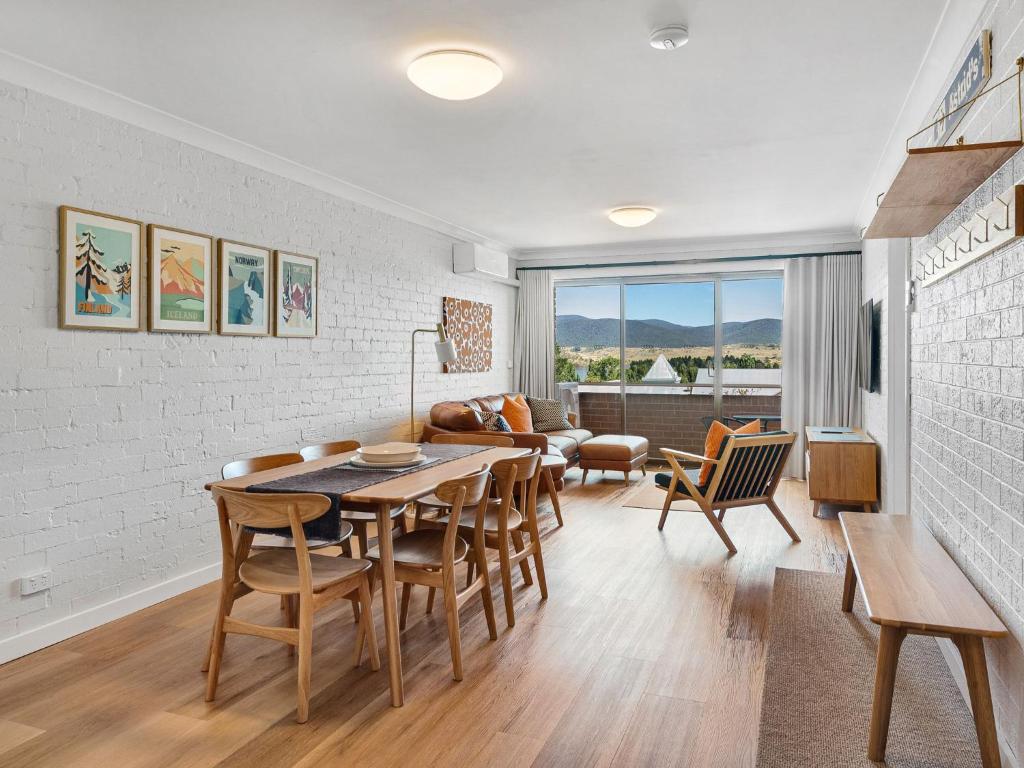a kitchen and living room with a table and chairs at Astrids at Central Park in Jindabyne