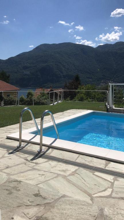 a swimming pool in a yard with mountains in the background at Villa Monte Bianco in Mandello del Lario