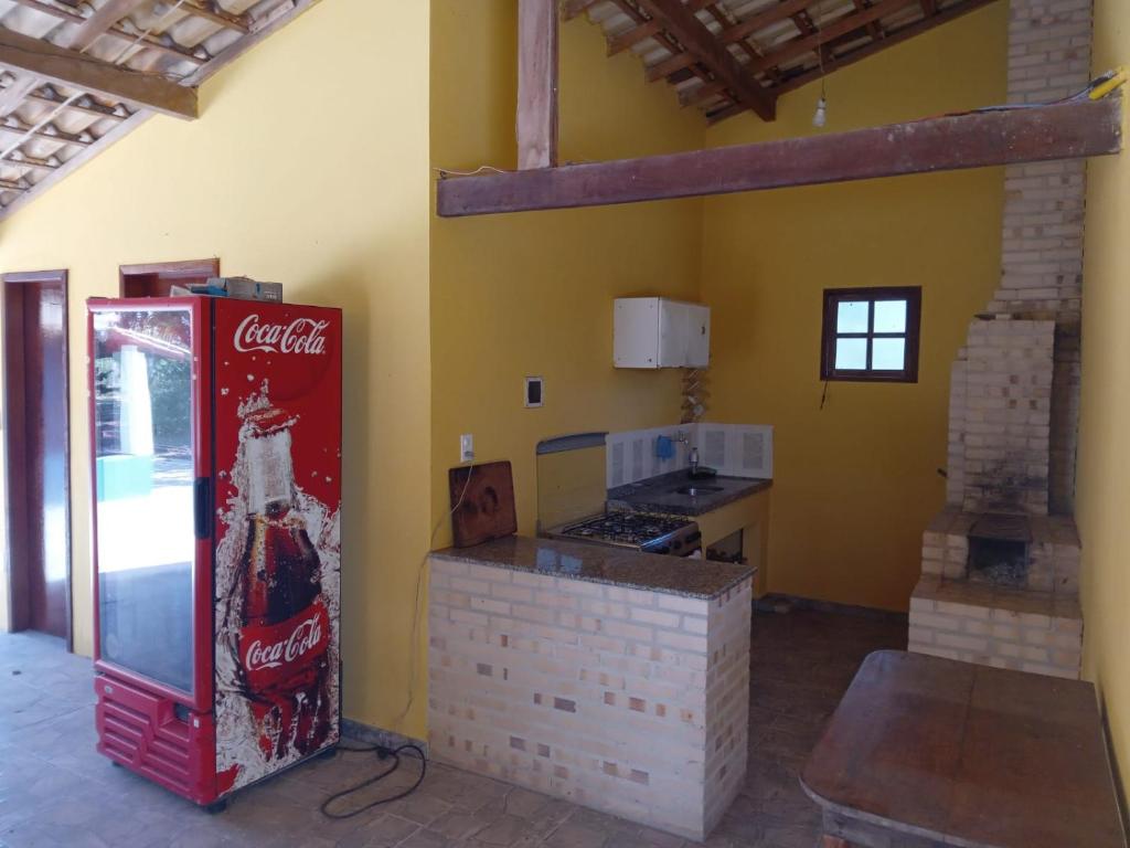 uma cozinha com uma máquina de cocacola num quarto em Pousada Estância Park em Amontoado
