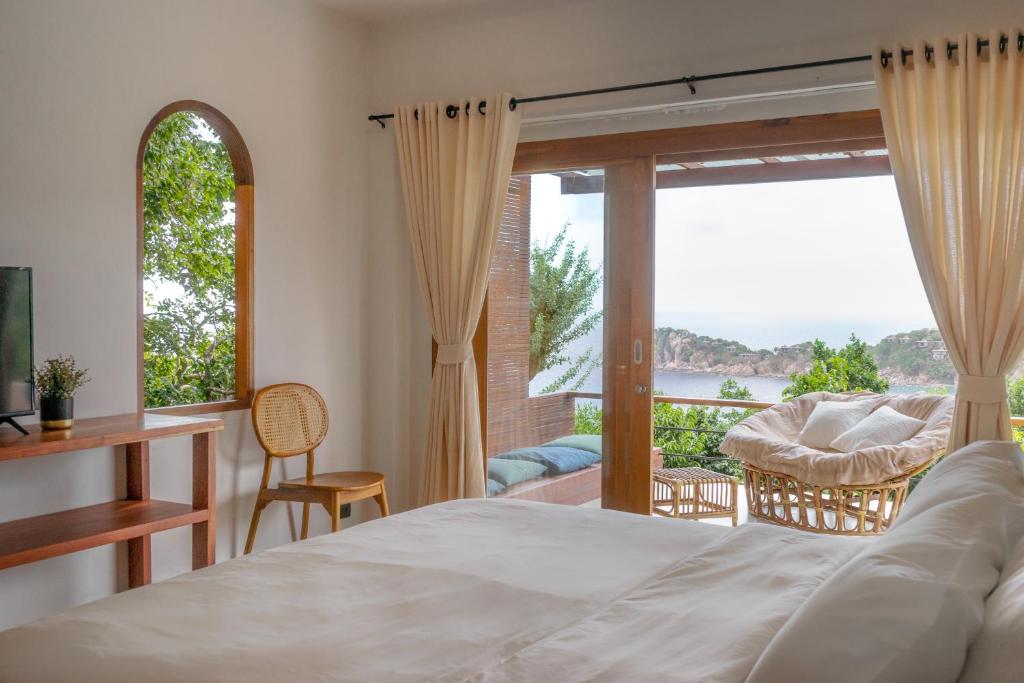 Un dormitorio con una cama y una ventana con vistas. en Baan Talay Resort & Yoga, en Ko Tao